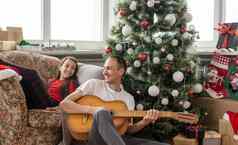 父亲女孩有趣的圣诞节假期爸爸戏剧吉他女儿休闲好爱的有爱心的爸爸婴儿快乐的有胡子的男人。执行歌曲