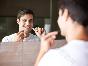 好牙科卫生使强大的牙齿年轻的男人。用牙线清洁牙齿牙齿镜子