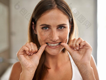 美开始才华横溢的微笑肖像年轻的女人用牙线清洁牙齿牙齿浴室
