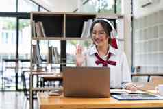 微笑亚洲女人耳机挥舞着手移动PC屏幕调用中心操作符咨询客户端客户学生学习语言导师老师培训在线