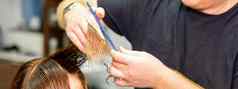 手理发师持有头发海滩手指使发型长头发年轻的女人梳子剪刀理发师沙龙关闭