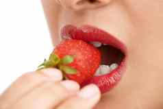 新鲜红色的裁剪特写镜头拍摄年轻的女人咬草莓