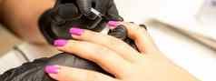 专业修指甲指甲修饰师绘画女指甲客户端紫色的指甲波兰的美沙龙关闭美行业概念
