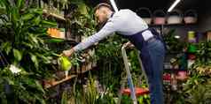 男人。照顾盆栽植物花园商店
