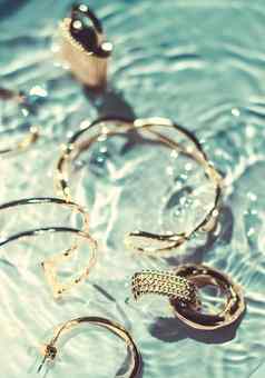 金手镯耳环环Jewelery翡翠水背景奢侈品魅力假期美设计珠宝品牌广告