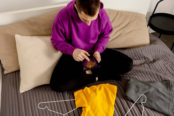 男人。紫罗兰色的连帽衫数字平板电脑需要照片衣服出售在线销售网站电子商务重用<strong>二手</strong>概念有意识的消费者可持续发展的生活方式