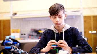 男孩年戏剧设计师多维数据集盘子电路电线小发明家创建机器人机器部分设计师