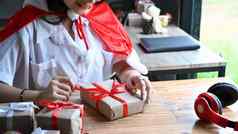 快乐年轻的女人装修圣诞节礼物红色的丝带