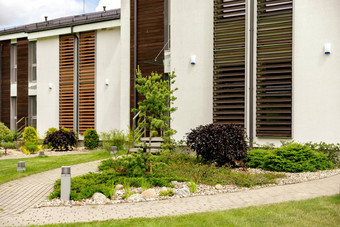 植物石头前面现代房子前面院子里景观设计美丽的花园现代城市生活住宅私人庭院绿色户外设施草坪上花园护理