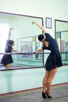 年轻的优雅的女人练习芭蕾舞工作室