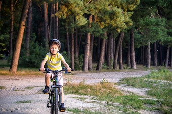 肖像快乐活跃的十几岁的男孩安全头盔放松学校骑自行车美丽的公园阳光明媚的秋天一天