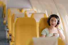 年轻的亚洲女人智能手机连接无线网络互联网飞行董事会旅行概念