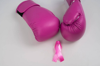 粉红色的拳击手套粉红色的丝绸丝带白色背景乳房癌症概念