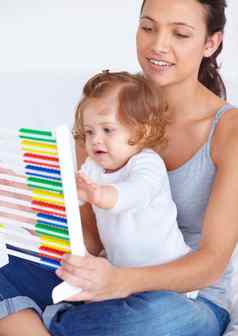 学习首页年轻的妈妈。教学婴儿女儿基础知识数学算盘