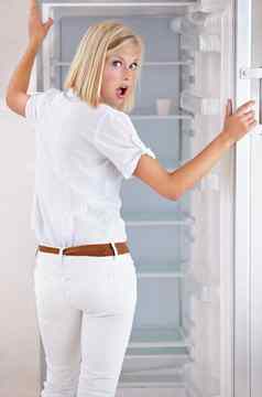 冰箱空肖像美丽的年轻的女人空冰箱