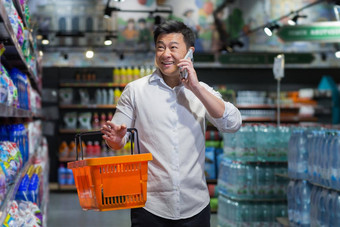 亚洲商人走超市篮子产品会谈电话