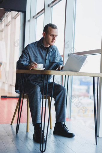 年轻的成功的商人西装饮料咖啡作品咖啡馆无线免费的互联网移动PC坐着表格咖啡馆