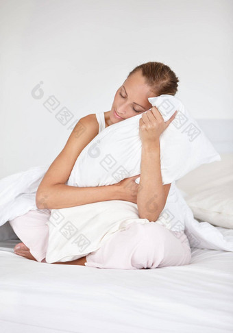 感觉安抚了最喜欢的枕头美丽的年轻的女人拥<strong>抱枕</strong>头床上