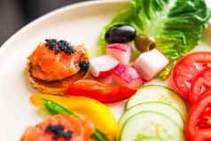 开胃菜盘大马哈鱼黑色的鱼子酱切片新鲜的蔬菜热情好客美食