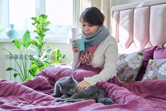 女人坐着首页床上气候变暖围巾杯子灰色的猫