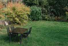 花园小酒馆表格椅子咖啡酒吧餐厅空白色木表棕色（的）椅子太阳草污垢阳光明媚的夏天一天木座位城市公园野餐公园休息开放区域