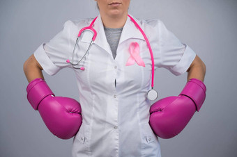 不知名的女医生<strong>粉</strong>红色的拳击手套<strong>粉</strong>红色的丝带灰色的背景战斗乳房癌症