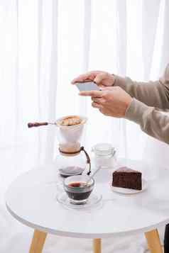 英俊的亚洲采取照片巧克力蛋糕牛奶咖啡商店甜点食物摄影爱好智能手机移动电话摄影习惯概念