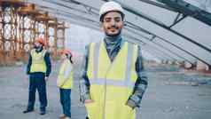 肖像阿拉伯男人。穿安全头盔背心站建设网站
