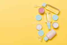 前视图作文小旅行瓶罐子化妆品产品黄色的背景面部皮肤护理概念复制空间设计