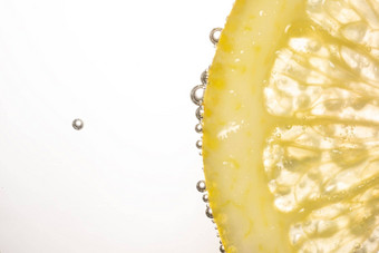 宏照片<strong>柠檬片</strong>水泡沫孤立的白色背景新鲜健康的生活方式概念
