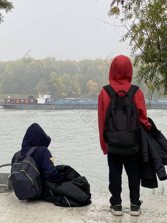 深思熟虑的男孩抽油烟机卡戈船航行多瑙河河冷平静冬天一天概念