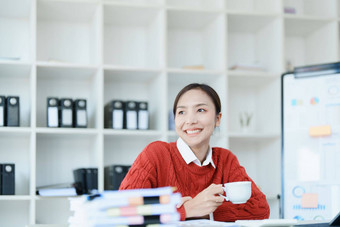 肖像亚洲业务女人喝咖啡工作电脑金融语句文档桌子上