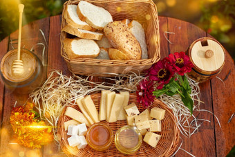 Jar甜蜜的蜂蜜奶酪玫瑰新鲜的面包明亮的光美丽的装饰有创意的照片桶木表格花园花早餐美味的食物