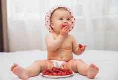 可爱的染色婴儿他画草莓吃浆果