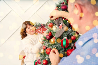 微笑快乐中间年龄夫妇装修圣诞节树首页快乐夫妇首页圣诞节概念