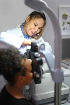 年轻的女人眼科医生检查眼睛愿景病人演出眼镜眼睛健康检查概念