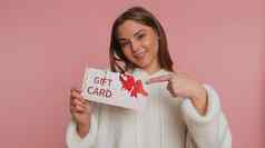 年轻的女人显示指出礼物折扣证书凭证优惠券商店假期出售