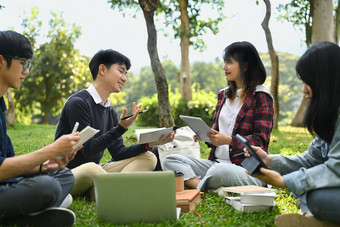 快乐大学<strong>学生会</strong>说话的放松校园草坪上工作移动PC教育生活方式概念