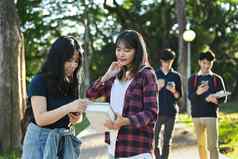 拍摄友好的女学生会说话的类走大学校园在户外
