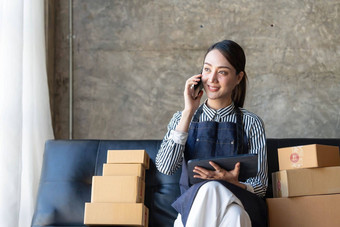 启动小业务企业家锻造自由女人工作聪明的电话年轻的亚洲小业务老板电脑在线市场包装盒子交付锻造电子商务电话销售概念