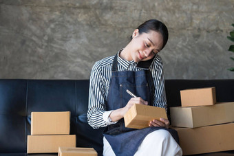 启动小业务<strong>企业</strong>家锻造自由女人工作聪明的电话年轻的亚洲小业务老板电脑在线市场包装盒子交付锻造电子商务电话<strong>销售</strong>概念