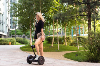 女人骑电迷你赛格威徘徊董事会踏板车绿色公园好夏天天气生态城市运输技术漂亮的模型电自动平衡踏板车董事会