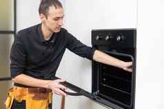 设备修复男人。安装电烤箱厨房