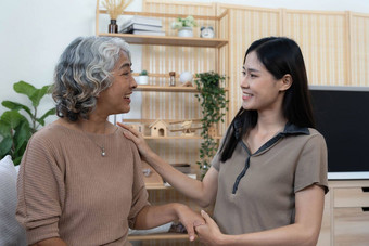 肖像亚洲可爱的家庭年轻的女儿拥抱老妈妈。有吸引力的女人高级老成熟的妈妈坐沙发享受<strong>活动首页</strong>生活房间微笑相机