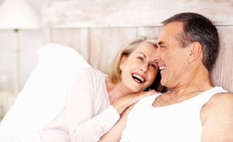 快乐的成熟的夫妇支出时间床上肖像快乐的成熟的夫妇支出时间床上