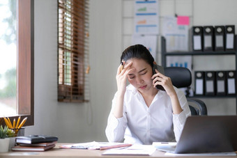 亚洲女商人<strong>移动</strong>PC电脑会说话的电话咨询客户<strong>端</strong>坐桌子上集中女销售经理使<strong>移动</strong>业务调用讨论工作客户办公室