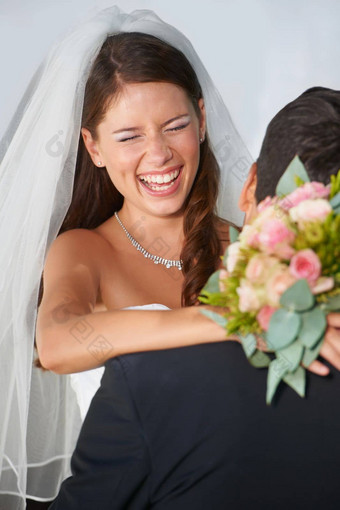 有趣的大一天很高兴年轻的新娘拥抱丈夫持有花束