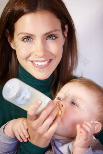 什么婴儿营养漂亮的年轻的妈妈。奶瓶喂养婴儿儿子