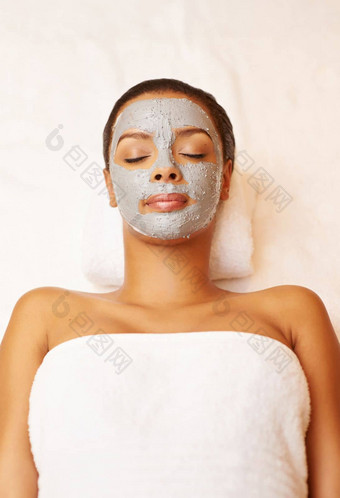 面部年轻的女人享受护肤品治疗水疗中心