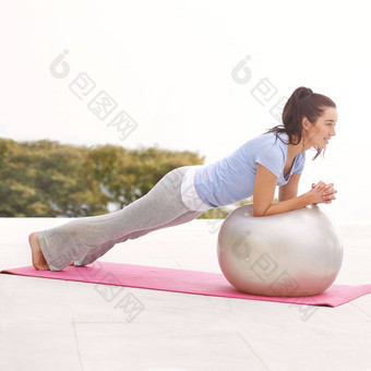 让<strong>球滚动</strong>完整的长度拍摄年轻的女人瑜伽在户外